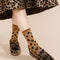 up close of model wearing light brown crew socks with black and brown leopard print