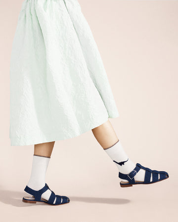 model wearing white crew socks with blue dino print