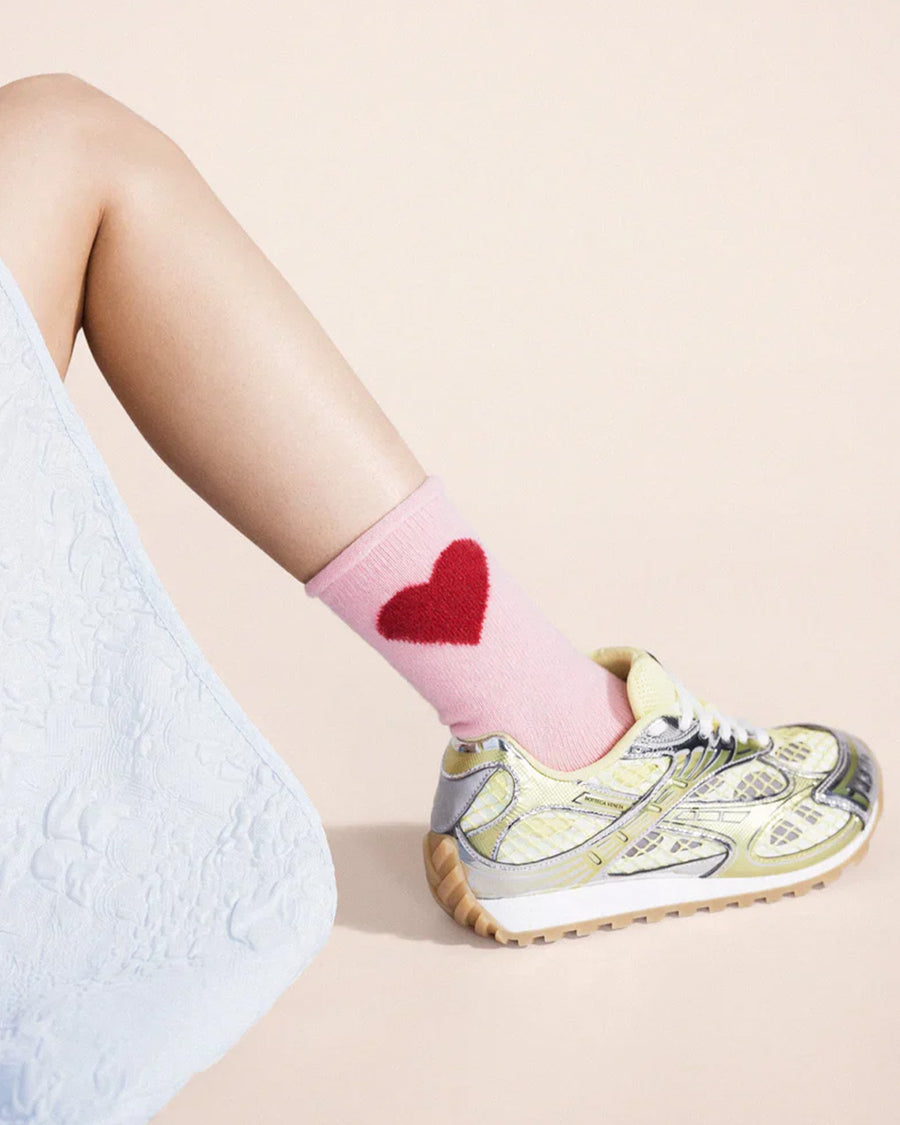 up close of model wearing pink socks with red heart