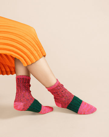 model wearing pink and green space dye and speckled socks