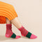 model wearing pink and green space dye and speckled socks