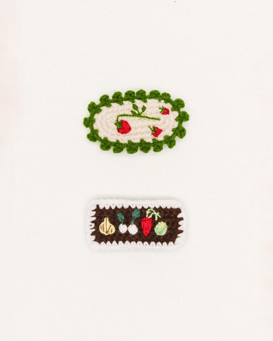 set of 2 hair clips: white strawberries with green border and brown veggies with white border