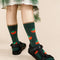 model wearing green crew socks with all over tomato prints