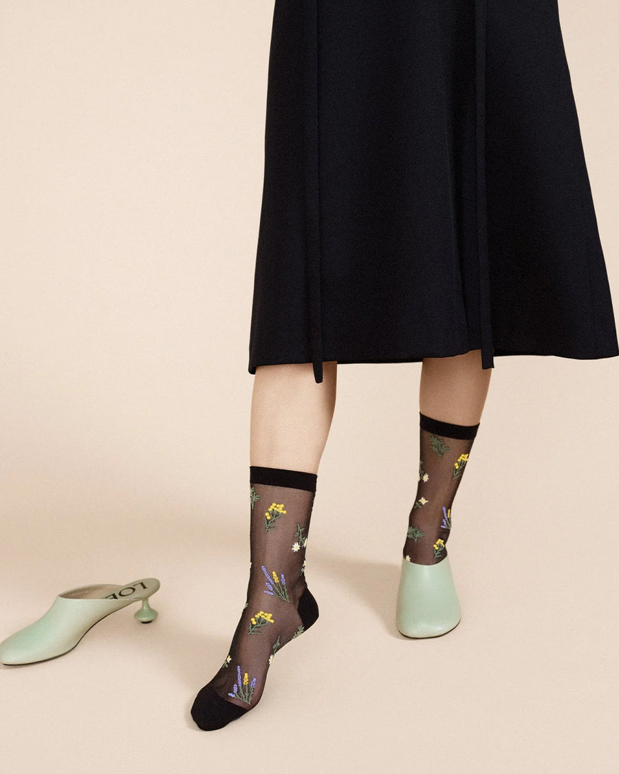 model wearing black sheer socks with colorful wildflower print