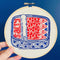 model holding red and blue tin sardine embroidery kit