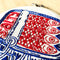 up close of red and blue tin sardine embroidery kit