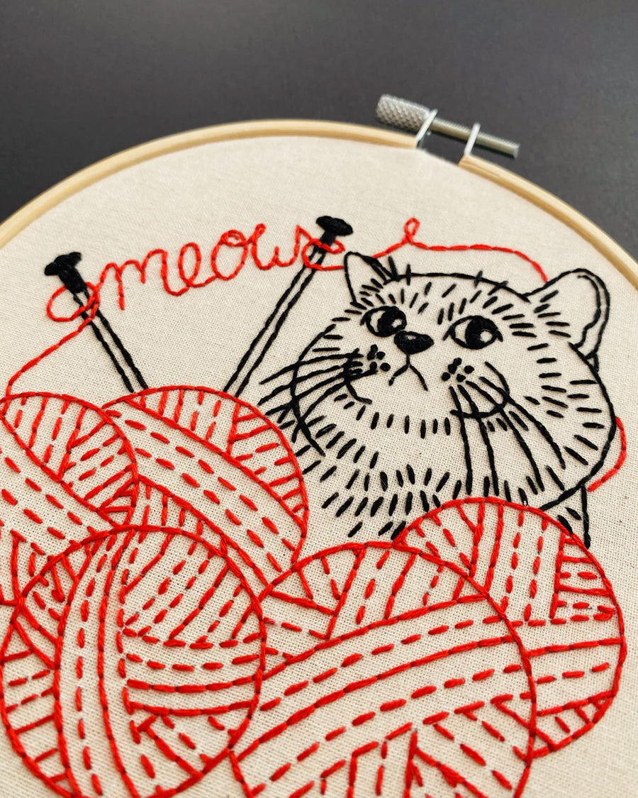 up close of red and black cat and knitting yarn embroidery kit