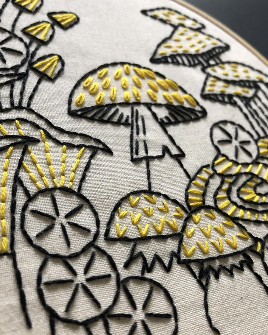 up close of black and yellow mushroom embroidery kit