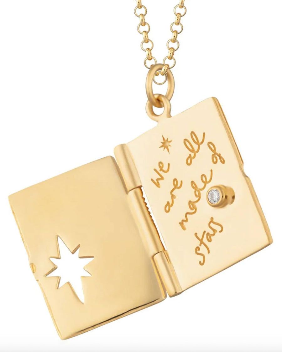 gold locket necklace with celestial scene and says 'we are all made of stars' inside