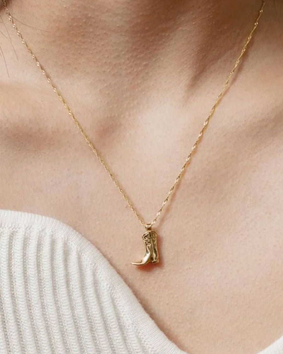 model wearing gold cowboy boot necklace