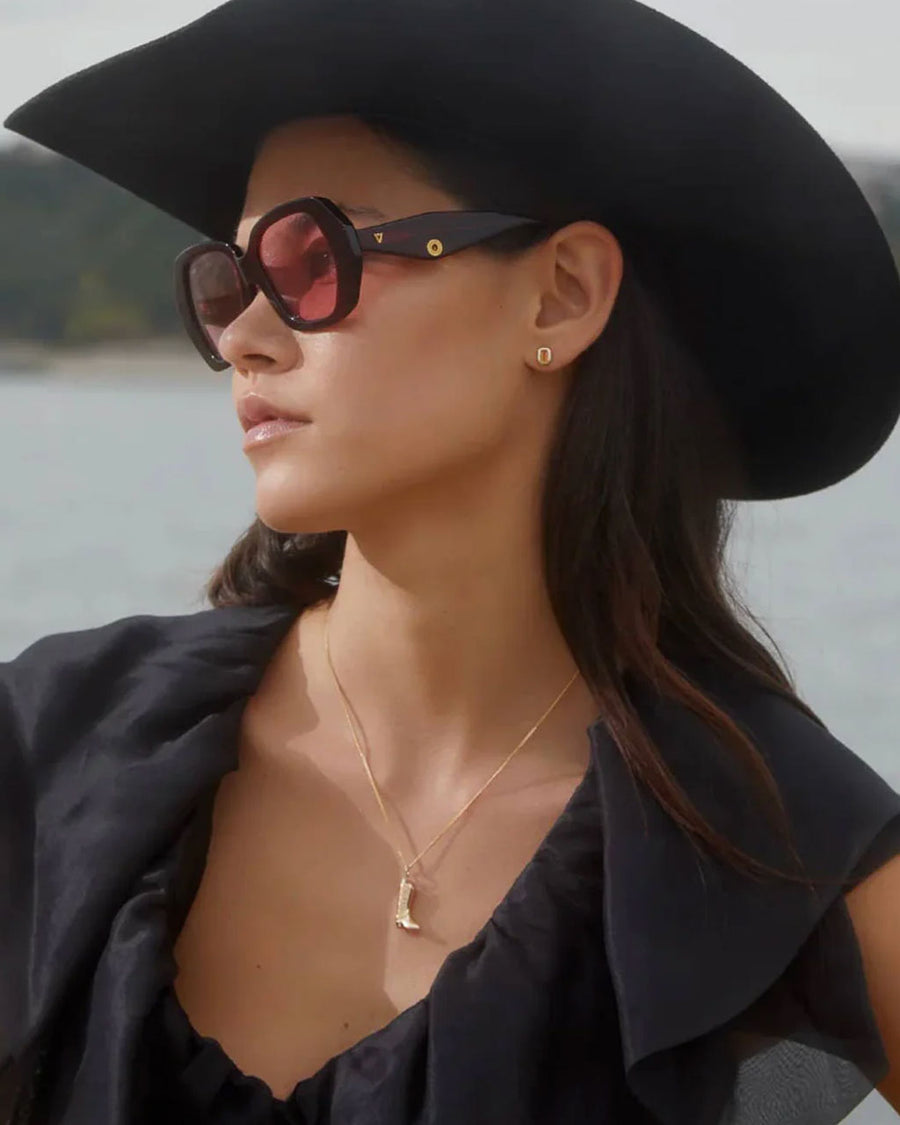 model wearing gold cowboy boot necklace