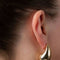 model wearing gold designer drop earrings