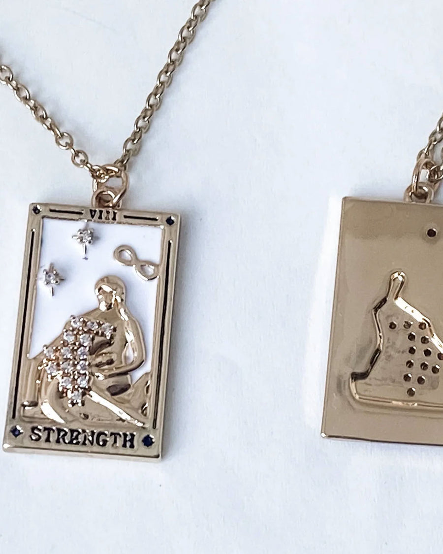 front and back view of gold strength tarot card necklace