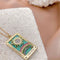 side view of gold sun tarot card necklace with colorful crystals 