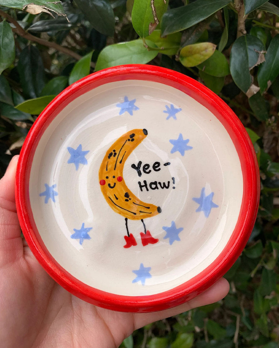 handmade trinket tray with red trim and yee-haw banana in the center