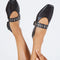 model wearing black mary jane flats with elastic back and thick buckle strap with silver grommets and buckle