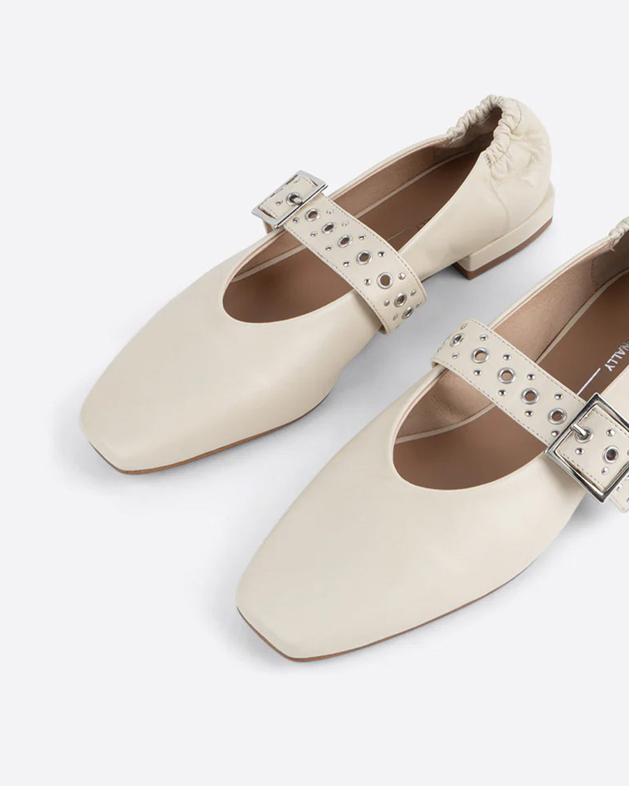 up close of creme mary jane flats with elastic back and thick buckle strap with silver grommets and buckle