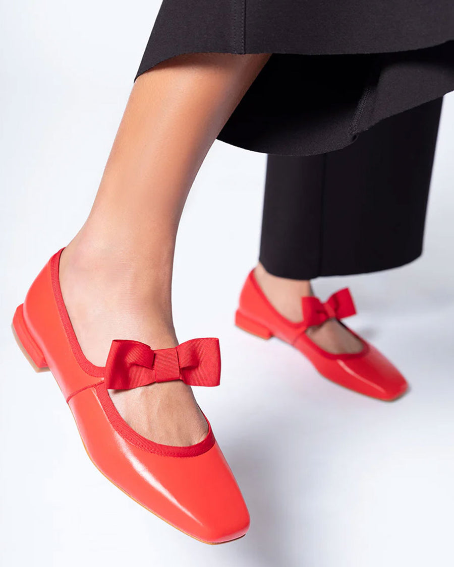 model wearing cherry red mary jane shoes with bow strap