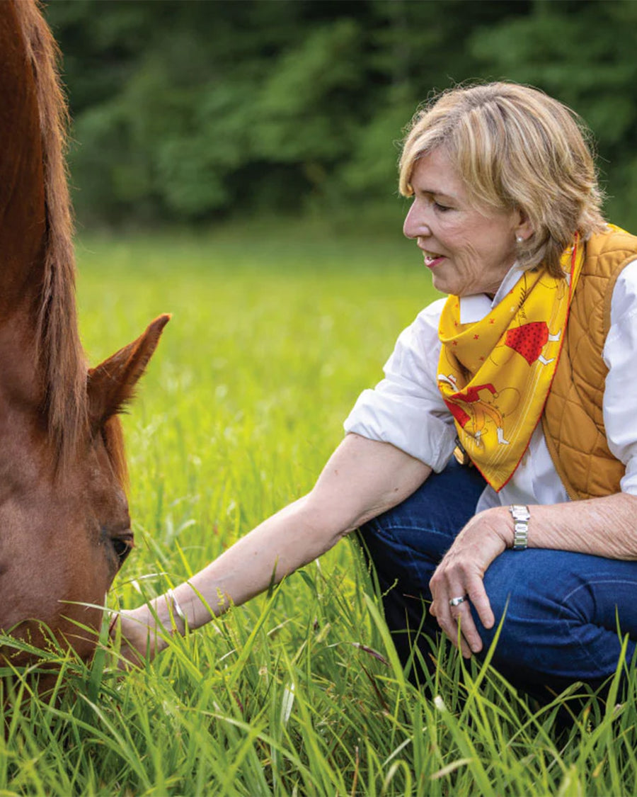 model wearing golden yellow square silk bandana with cowboy and cowgirl trim with red accents