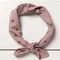 tied mauve square bandana with dainty hand holding a flower and all over dainty print