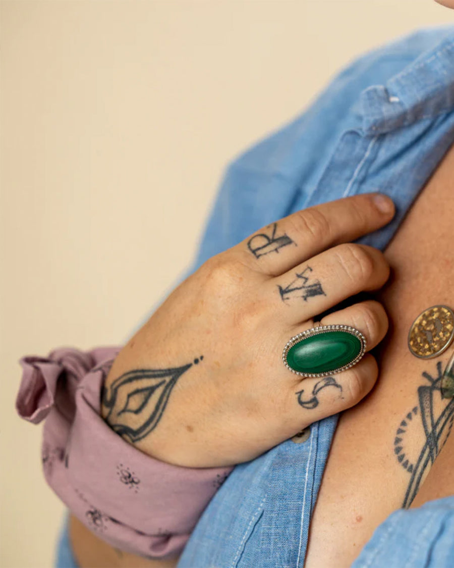 model wearing mauve square bandana with dainty hand holding a flower and all over dainty print on their wrist