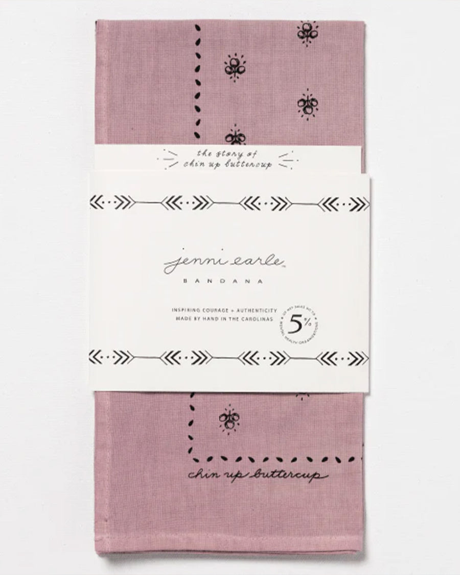 packaged mauve square bandana with dainty hand holding a flower and all over dainty print