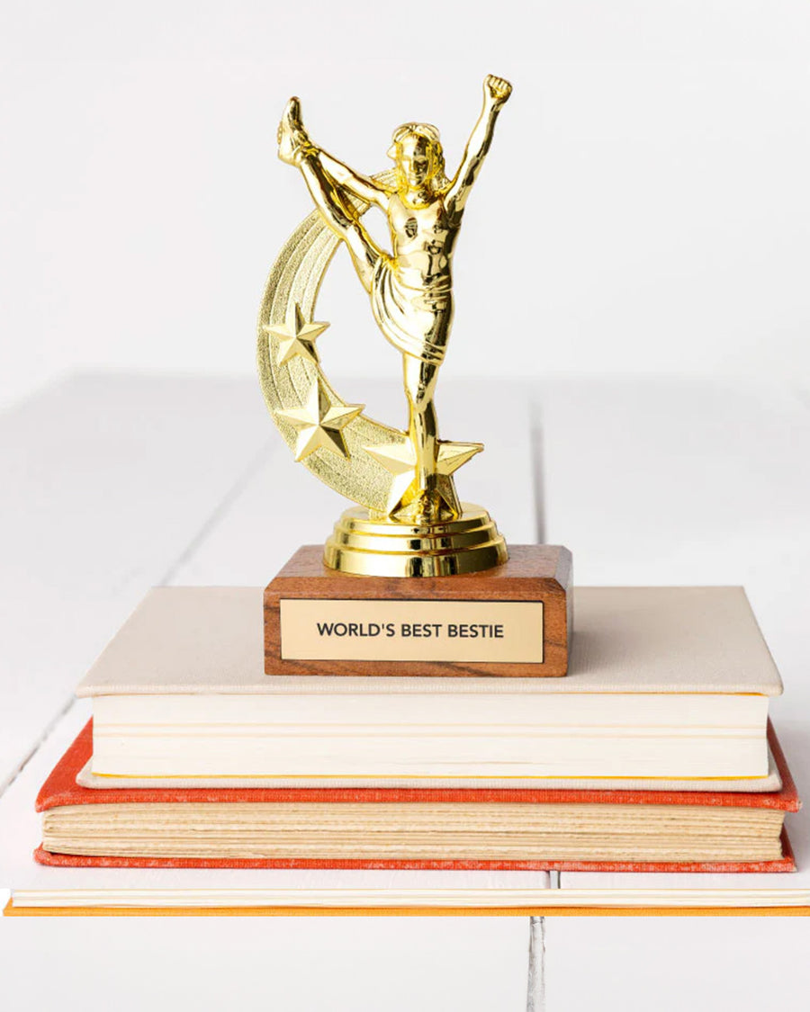 'world's best bestie' gold trophy on a stack of books