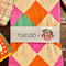 packaged pink, orange, yellow and green diamond tea towel