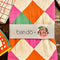 packaged pink, orange, yellow and green diamond tea towel