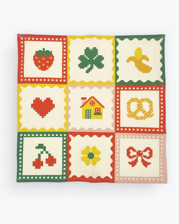 cream tea towel with strawberry, shamrock, banana, heart, house, pretzel, cherry, flower and bow icons