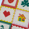 up close of cream tea towel with strawberry, shamrock, banana, heart, house, pretzel, cherry, flower and bow icons