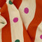 up close of pale yellow and orange striped tea towel with green and pink dots