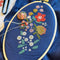 incomplete blue cross stitch kit with colorful flowers