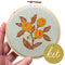 model holding light blue embroidered cross stitch kit  with yellow flowers