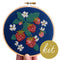 model holding navy blue embroidered cross stitch kit with strawberry and white floral print