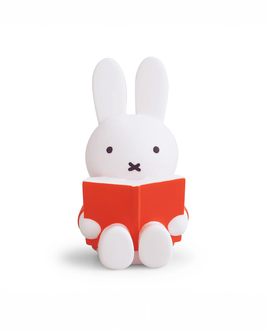 medium miffy sitting and reading a red book