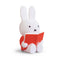 side view of medium miffy sitting and reading a red book