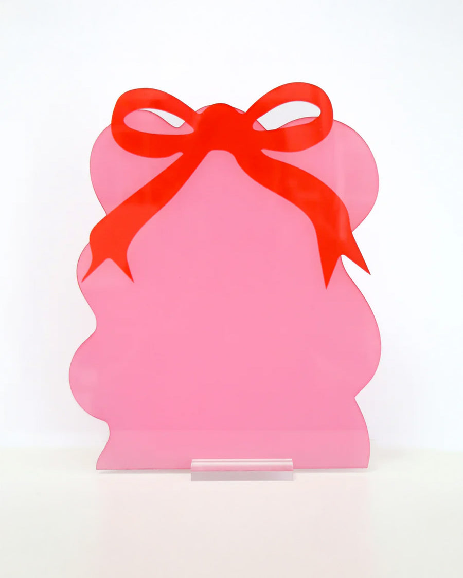 pink squiggle dry erase board with red bow on the top