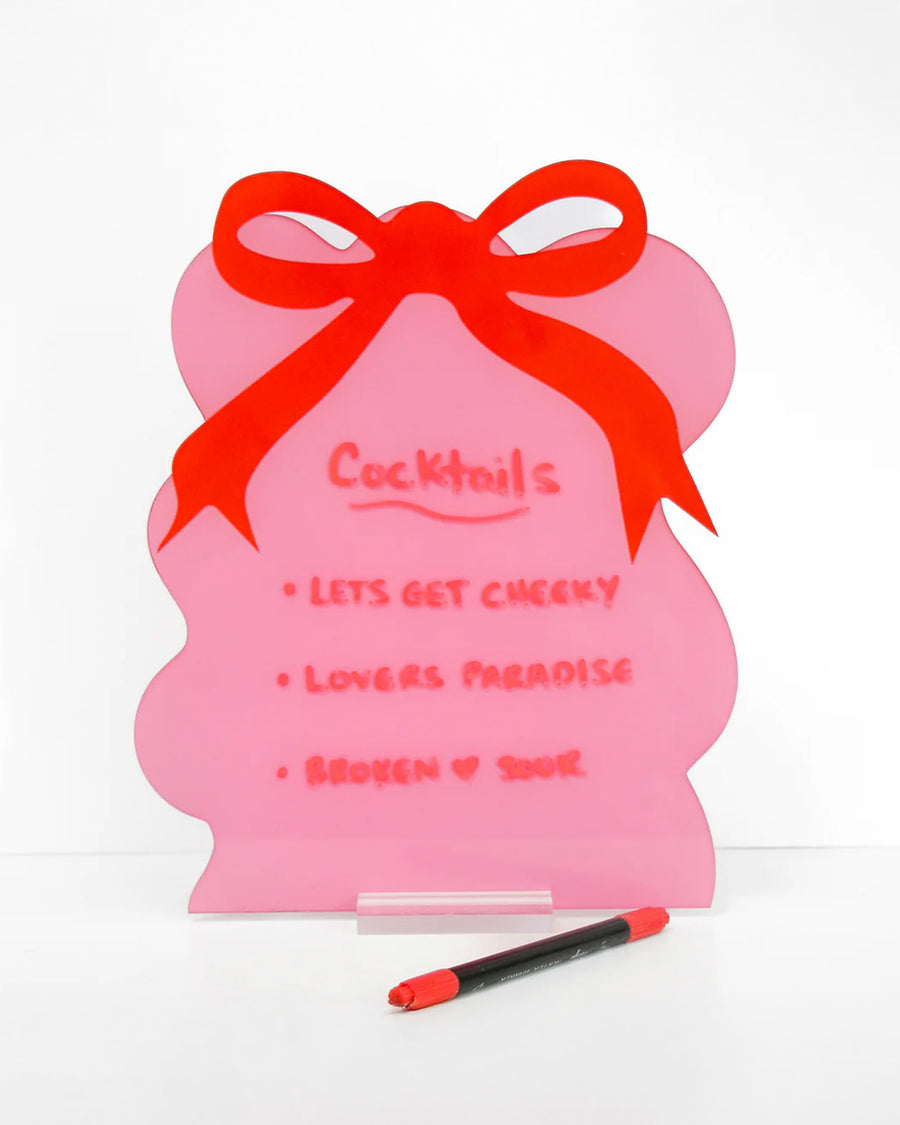 pink squiggle dry erase board with red bow on the top with cocktail options written on it