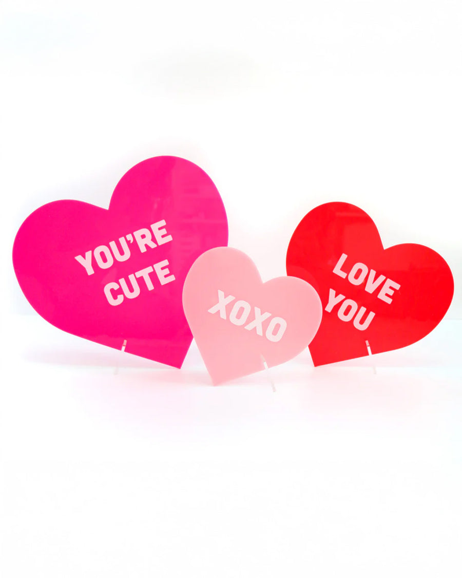 set of three acrylic conversation hearts: large hot pink 'you're cute, medium red 'i love you, and small light pink 'xoxo'