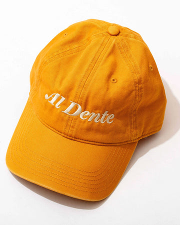 yellow baseball hat with cream embroidered 'al dente' across the front