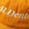 up close of yellow baseball hat with cream embroidered 'al dente' across the front