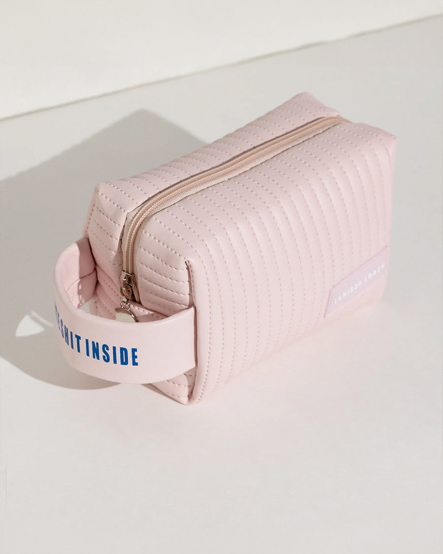 pink quilted bag with 'cute shit inside' on the handle