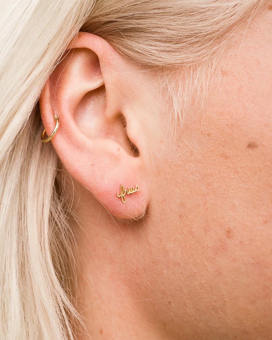 model wearing gold cursive 'fries' single stud earring