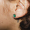 model wearing pair of green olive enamel earrings