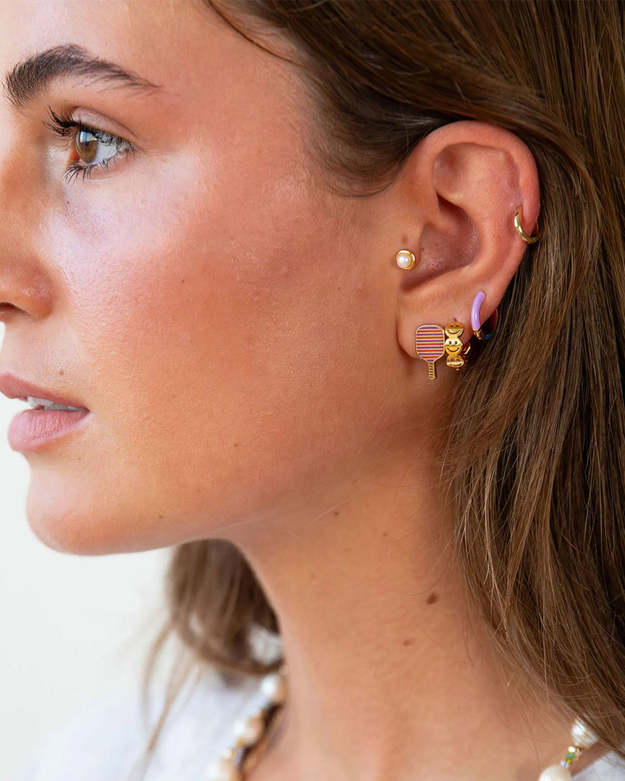 model wearing gold smiley hoop huggie earrings