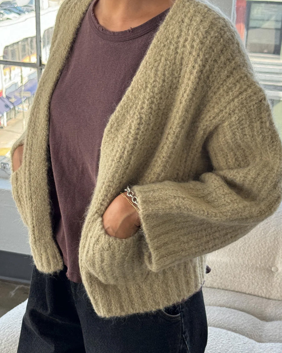 model wearing sand chunky knit open front cardigan with front patch pockets