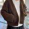 model wearing dark brown chunky knit open front cardigan with front patch pockets