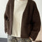 model wearing dark brown chunky knit open front cardigan with front patch pockets