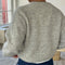 back view of model wearing light grey cardigan with white button front and front patch pockets